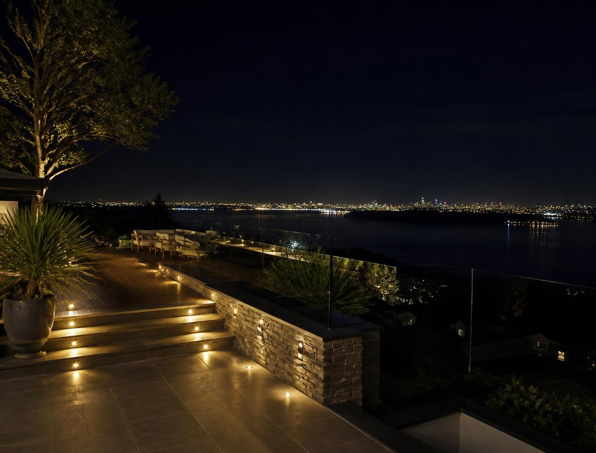 Terrace at night with recessed deck and step lighting overlooking distant city lights